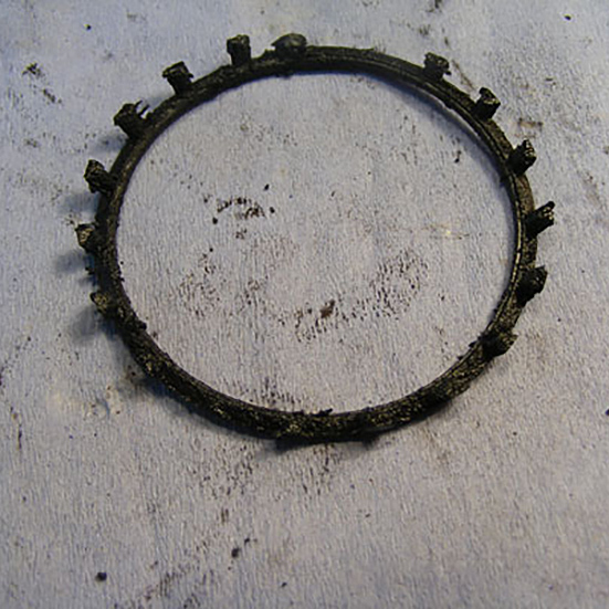 Tapered roller cage with worn side pillars caused by the bearing having run in a reduced lubricant condition