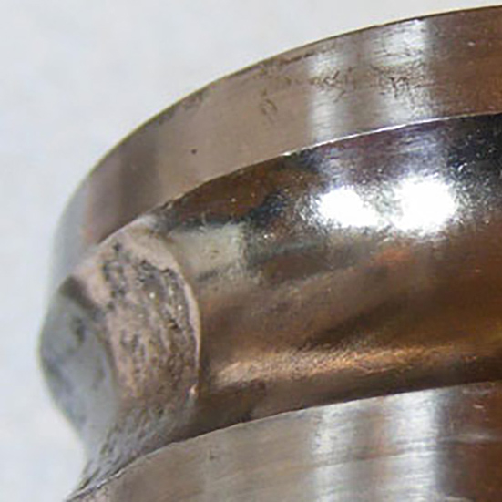 Pear skinning caused by metal debris from a fatigue failure being pressed onto the remainder of the contact surface