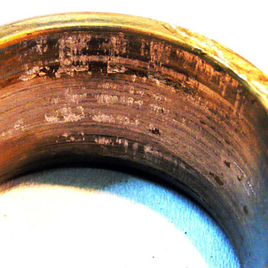 Rotation and surface wear in the bore of a tapered roller bearing inner ring. The possible cause being that the shaft was damaged previously allowing movement to occur