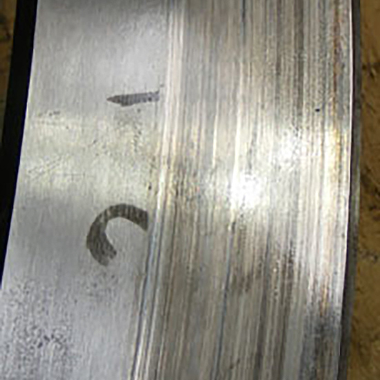 Top surface of a thrust bearing showing sliding wear marks to one side of the ring as a result of unintended movement during service