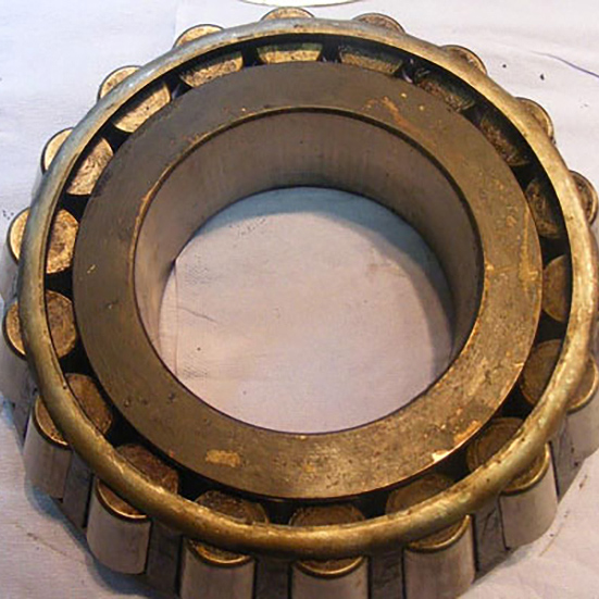 Damaged outer surface of a double row Tapered Roller Bearing, Marks consistent with the ring having been loose in the application due to housing wear and dimensional inaccuracy. Discolouration to a deep blue caused by overheating at one side as a result of uneven loading